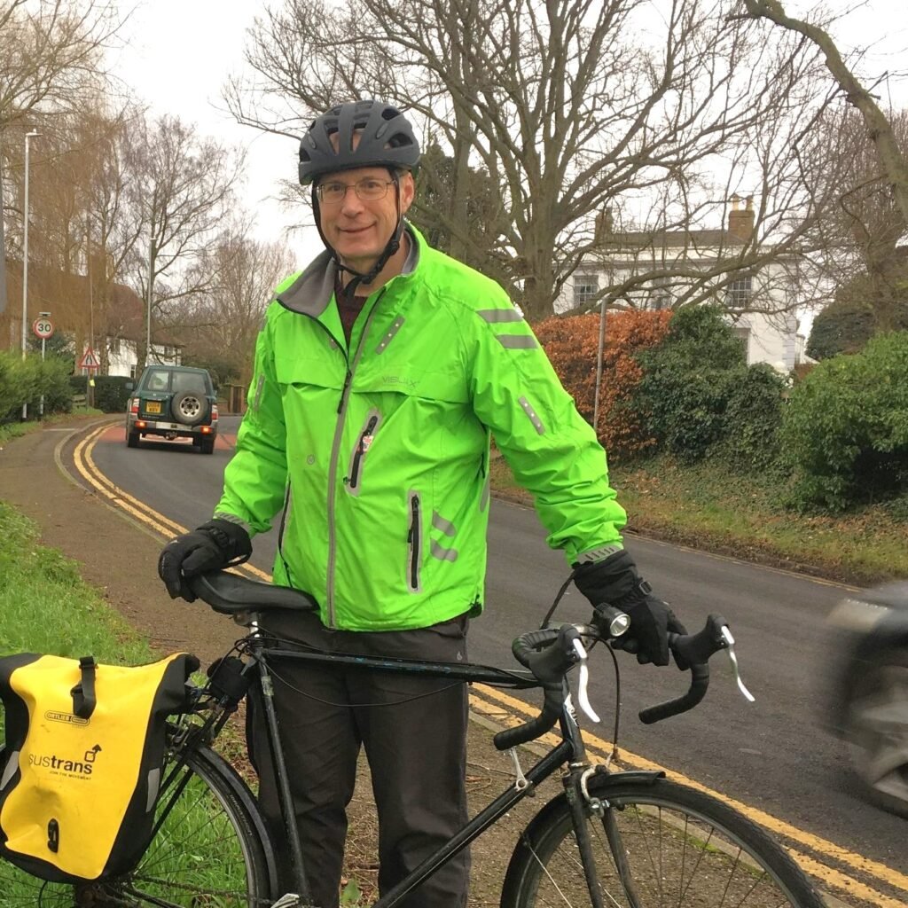 Photo of Alastair Gould with a bicycle on a country road