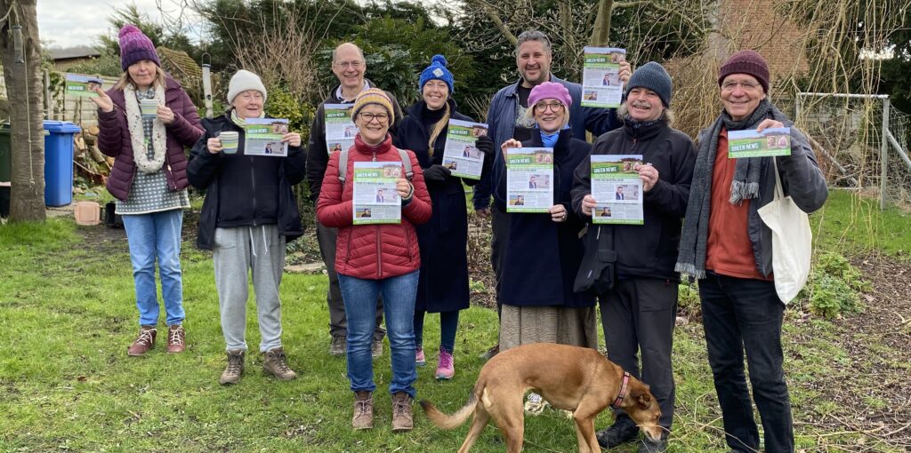 Photo of a group of people in a garden holding leaflets