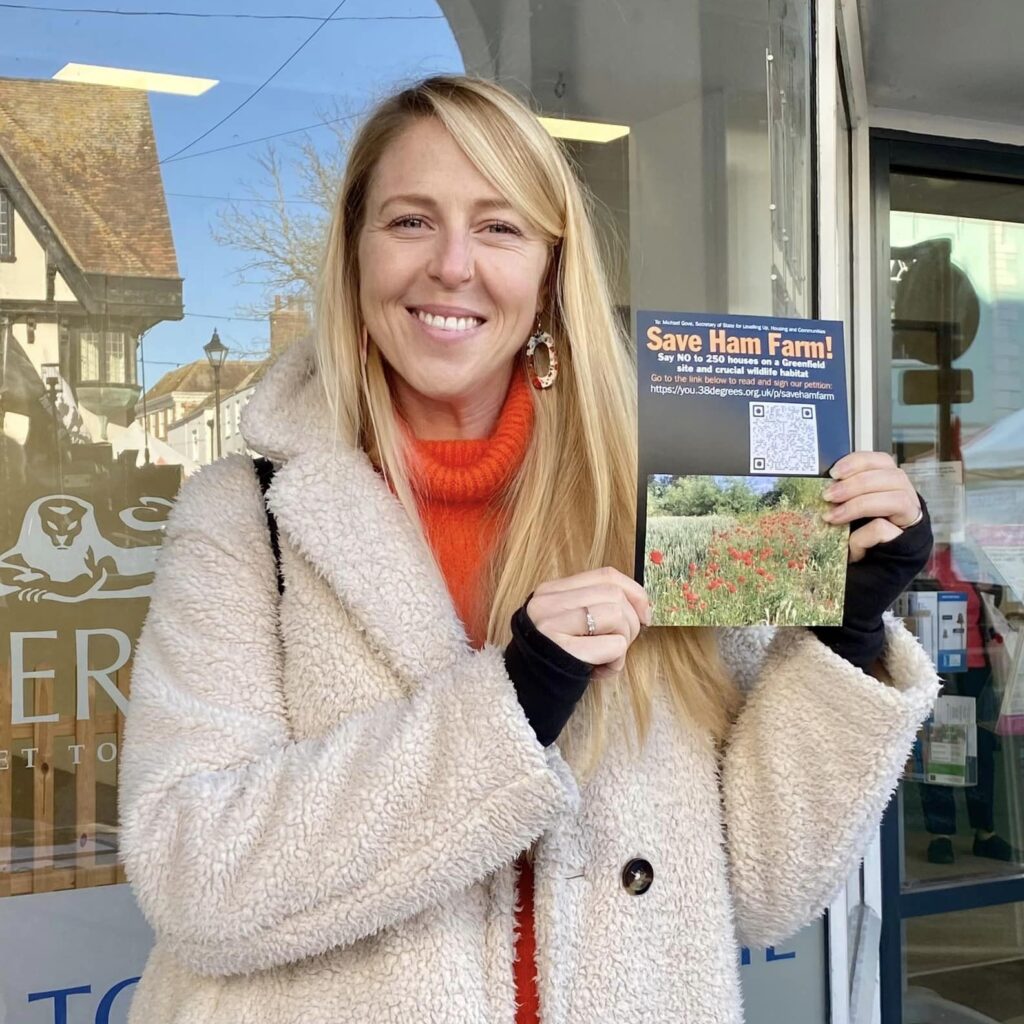 Photo of Hannah Temple with leaflet saying "Save Ham Farm"